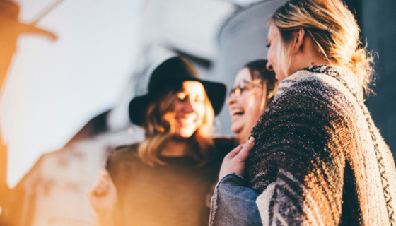 Enjoy group stays in Scotland - A close-up photo of a small group of 4 people laughing. (© Priscilla Du Preez on Unsplash)