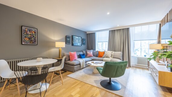 Living Room - An inviting and light-filled living area, designed with modern travellers in mind. It features comfortable seating, stylish furnishings and large windows that bring in natural light, creating a relaxing atmosphere in the heart of the city.
