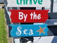 Thrive by the sea sign