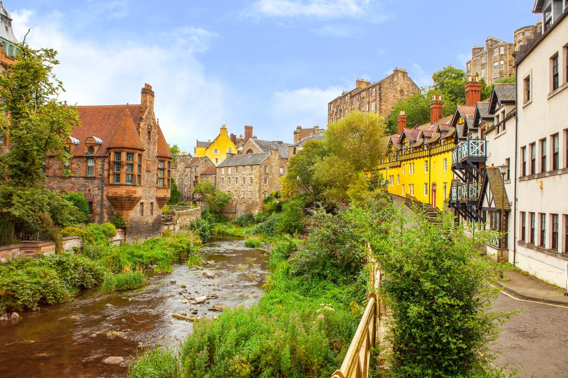 Why visit Dean Village in Edinburgh? - A river runs through a leafy suburb, with houses alongside the riverbank.