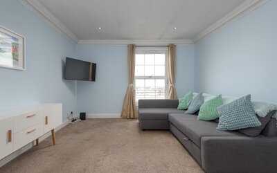 Living Room with Firth of Forth Views - Relax on the comfortable sofa while enjoying natural light and beautiful north-facing views towards the Firth of Forth. A peaceful retreat after exploring Edinburgh's vibrant Festival atmosphere.