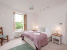 Old Church Lane 8 - Large double bedroom with green rug and pink throw