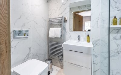 9e39a422-8d13-48ef-a028-aeb300c0ebe4 - Cosy bathroom featuring modern fixtures and a well-lit vanity area, offering a comfortable and functional space