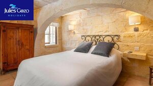 Case Study of Jules Gozo Holidays - A photo from Jules Gozo Holidays with a double bed in a bedroom with curved stone ceiling.