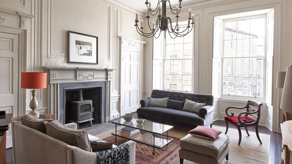 Lounge Area in a Self-Catered Apartment - Stylish lounge area featuring comfortable sofas and a piano, to unwind after a long day in the city of Edinburgh (© The Edinburgh Address)