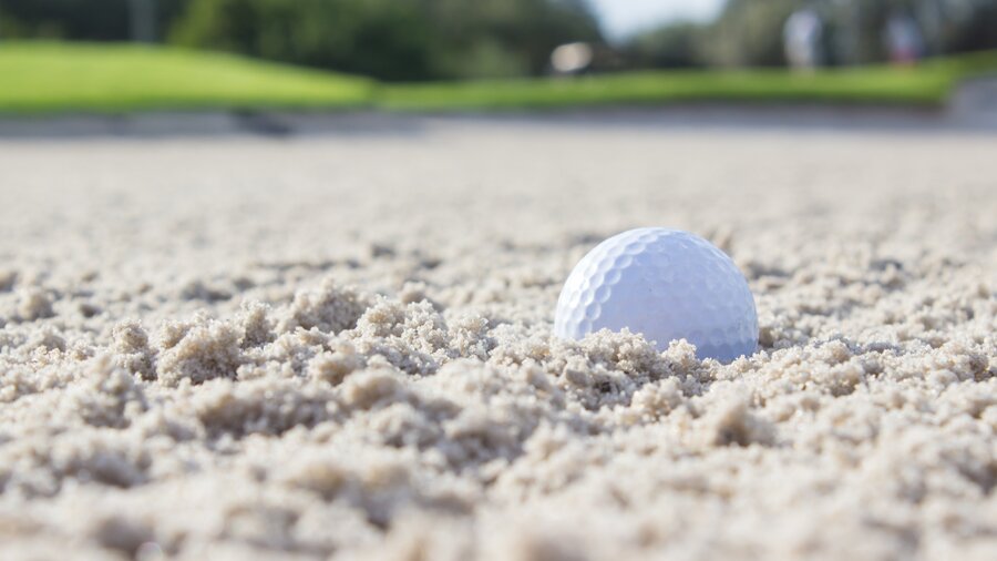 Golf ball in golf bunker - Golf ball in the sand of a golf bunker on a golf course (© Stephen Shircliff on Unsplash)