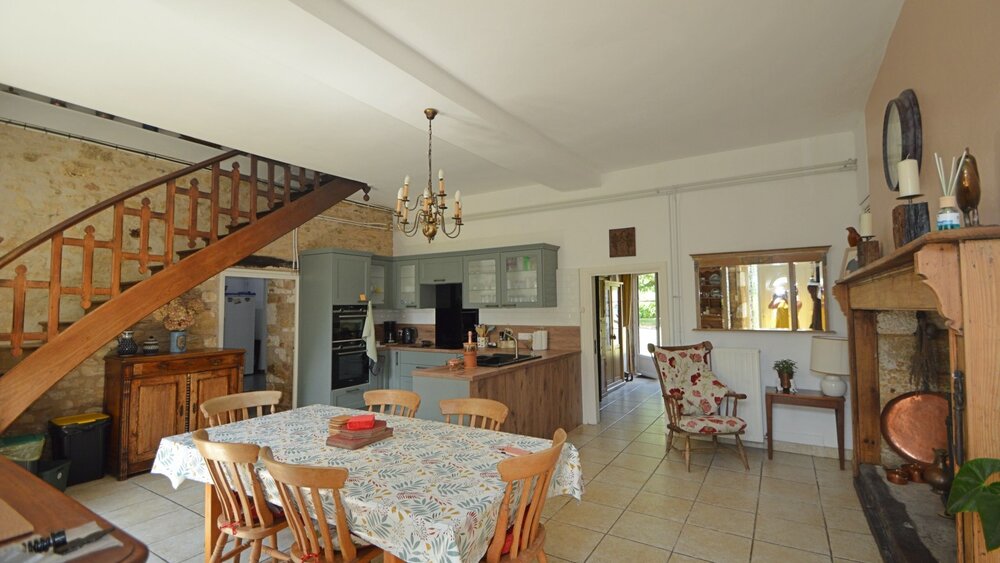 Kitchen Dining Room - Open plan kitchen dining room, large dining table, wood burning stove, cooker, appliances. Direct access to pool area. (© Voila Villas France)