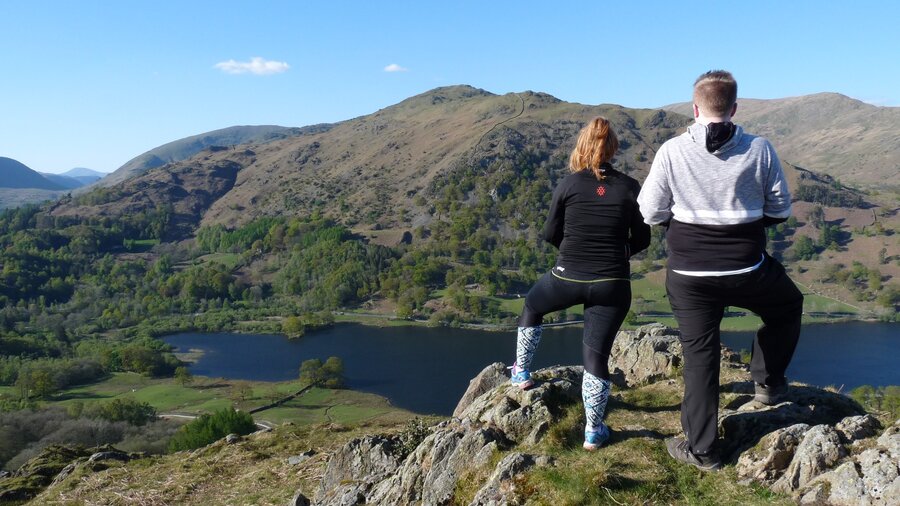 View of Lake Windermere from Loughrigg Fell - A couple enjoying the sunning fell and lake views from the top of Loughrigg Fell in the Lake District (© Cumbria Tourism) View of Lake Windermere from Loughrigg Fell - A couple enjoying the sunning fell and lake views from the top of Loughrigg Fell in the Lake District (© Cumbria Tourism)