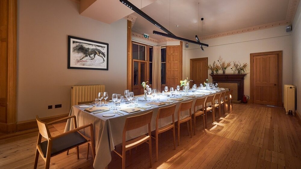 Luxury holiday accommodation for special occasions - Long wooden dining table set for 20+ guests.