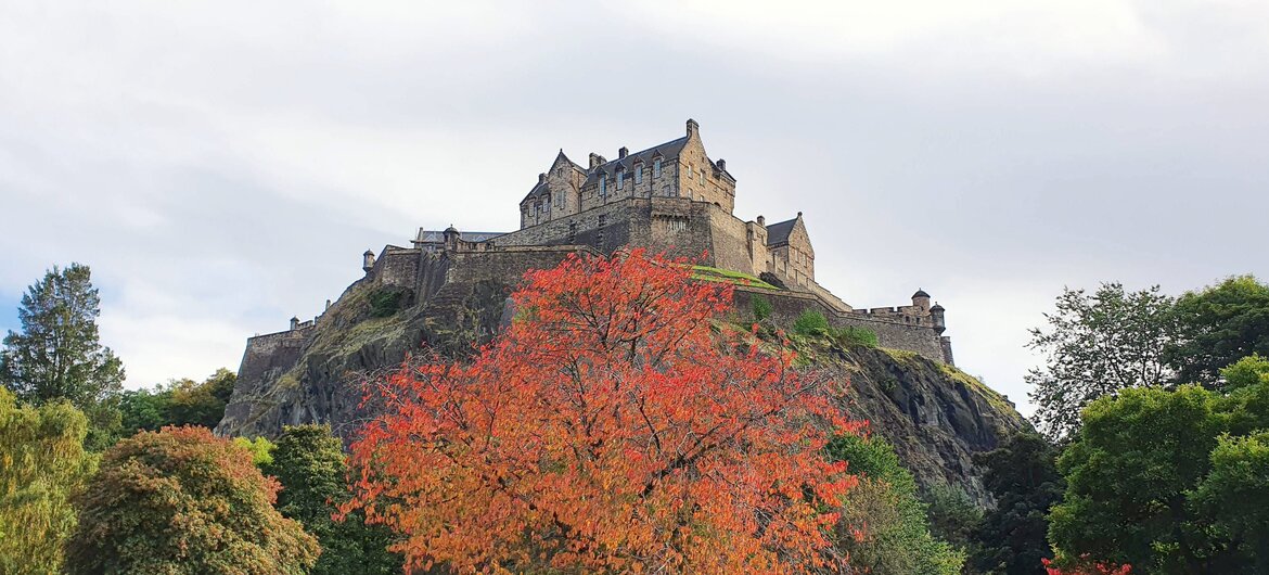 What's on in Edinburgh in October - Autumnal trees with orange leaves in front of Edinburgh Castle
