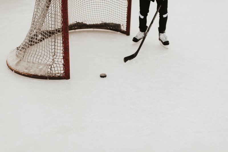 Skating - A person wearing ice skates holding a hockey stick in front of a goal. (© Samantha Gades on Unsplash) Skating - A person wearing ice skates holding a hockey stick in front of a goal. (© Samantha Gades on Unsplash)