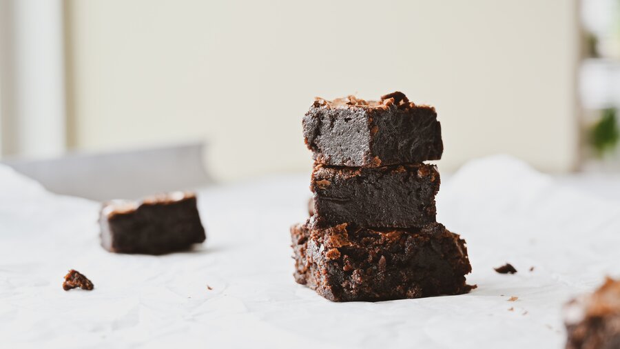 Chocolate brownies - 3 chocolate brownies in a pile with other brownies to the side (© Molly Keesling on Unsplash)