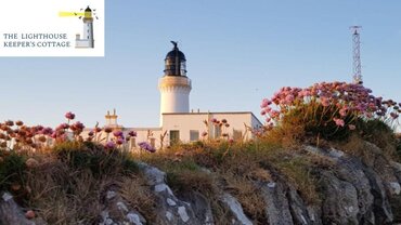Case Study of Lighthouse Keeper's Cottage - View of flowers in the foreground and a white lighthouse in the background.