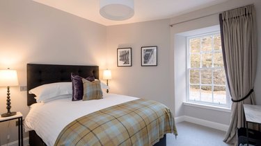 Master Bedroom with kingsize bed and tartan throw in Edinburgh West End Apartment.
