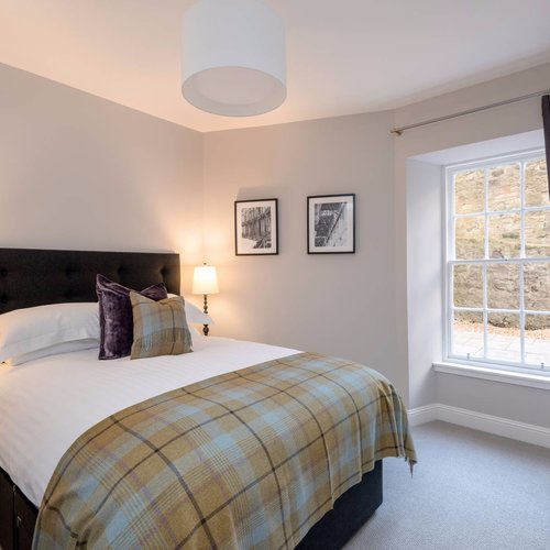 Master Bedroom with kingsize bed and tartan throw in Edinburgh West End Apartment.