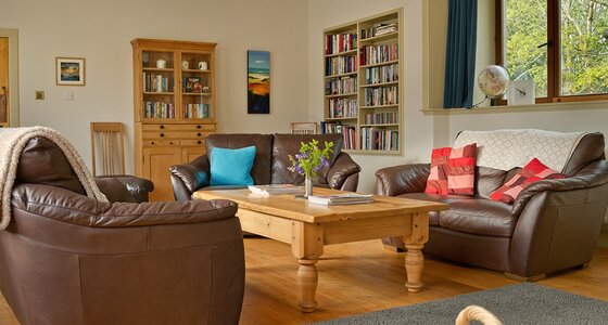 The Steading living room - Large living room with 3 settees, TV, games, books and coffee table.