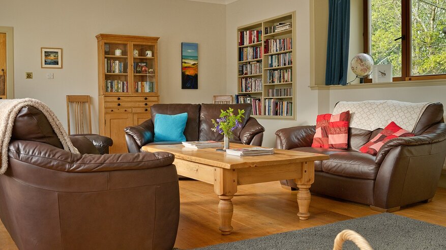 The Steading living room - Large living room with 3 settees, TV, games, books and coffee table.