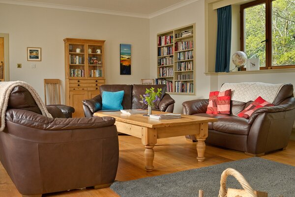 The Steading living room - Large living room with 3 settees, TV, games, books and coffee table.