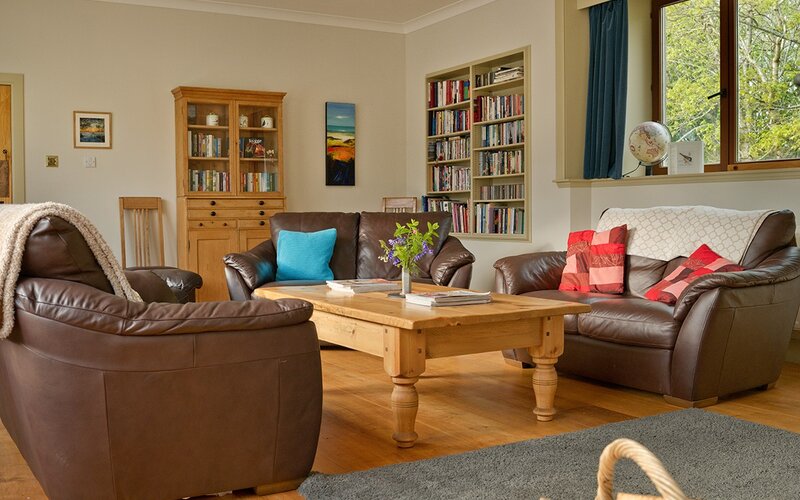 The Steading living room - Large living room with 3 settees, TV, games, books and coffee table.