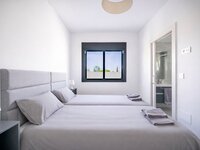 Modern twin bedroom with bathroom view