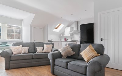 Edinburgh-Flats-self-catering-holiday-apartment-Royal-Mile-High-Street-lounge - Bright spacious Living/Dining/Kitchen open plan area with lovely wooden floors and 2 modern grey sofa and a double sofa bed which sleeps 2 people