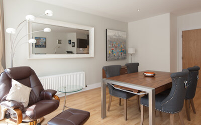 Dining Area For Business Travellers - Elegant dining room with a grand table, stylish chairs, and ambient lighting