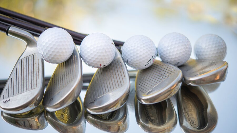 Golf clubs - Line of 5 golf clubs with golf balls (© cristina-anne-costello on Unsplash)