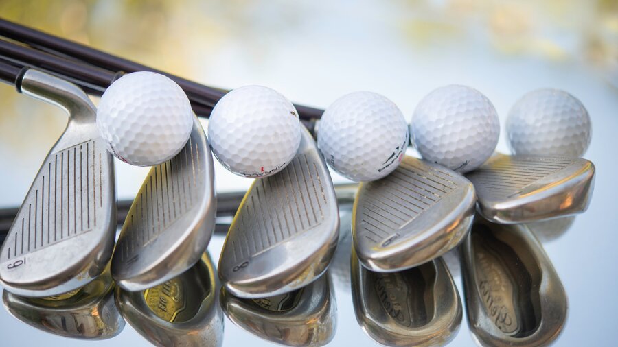 Golf clubs - Line of 5 golf clubs with golf balls (© cristina-anne-costello on Unsplash)