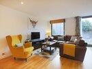 Living room/dining room - Stylish living room, with L shaped leather sofa, and accent yellow armchair in Edinburgh self catering accommodation.