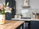 Contemporary Kitchen Island with Hob - The timber kitchen island creates a striking focal point within this contemporary Edinburgh apartment. Featuring a hob, overhead extractor and elegant navy cabinetry, this stylish space is perfect for social cooking and entertaining during your Edinburgh Fringe Festival stay.