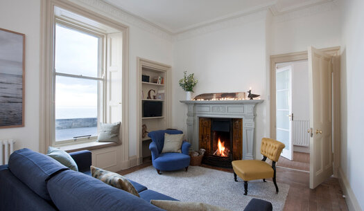 Seaside pet friendly apartment - Living room with open fire and sea views.
