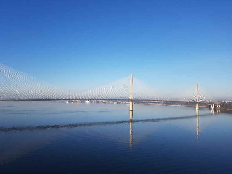 South Queensferry day trip view of The Queens Crossing - Blue skies reflect onto still waters with a white bridge. South Queensferry day trip view of The Queens Crossing - Blue skies reflect onto still waters with a white bridge.