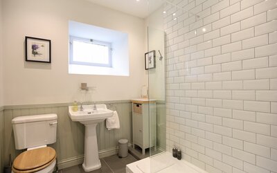 Shower room - Contemporary shower room featuring large tiled shower, toilet and wash hand basin in Edinburgh holiday accommodation.