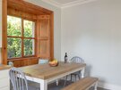 Dining area at SeaPink Cottage - Close up of original wooden frames, dining table and chairs in holiday rental.
