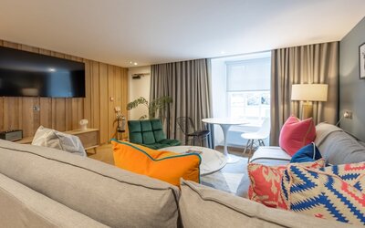 9e4a1003-b06a-4dc9-9c60-af1100db7087 - An inviting living room designed with modern travellers in mind. It features comfortable seating and stylish furnishings, creating a relaxing atmosphere in the heart of the city.