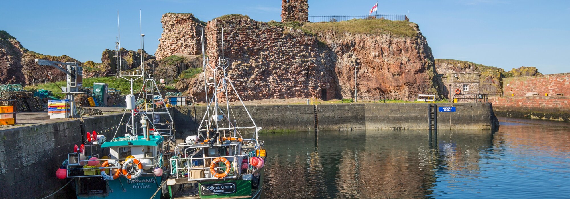Discover Dunbar - Two boats sit in the quiet harbour, with reflections on the still water. (© Amelia Whittaker) Discover Dunbar - Two boats sit in the quiet harbour, with reflections on the still water. (© Amelia Whittaker)