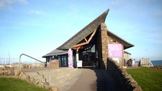 The Scottish Seabird Centre in East Lothian, Scotland - Image of The Scottish Seabird Centre building along a path. (© james denham, CC BY-SA 2.0 <https://creativecommons.org/licenses/by-sa/2.0>, via Wikimedia Commons)