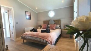 CS Holiday Lets Bedroom - A light double bedroom with a flower in the foreground.