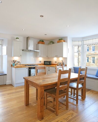 Dining Area - Beautiful kitchen featuring farmhouse style dining table, and bay window seating in Edinburgh self catering apartment.