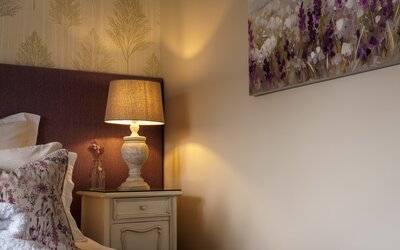 Bedroom in a Corporate Stay in Scotland - Close up of double bed with small bedside lamps and sophisticated artwork