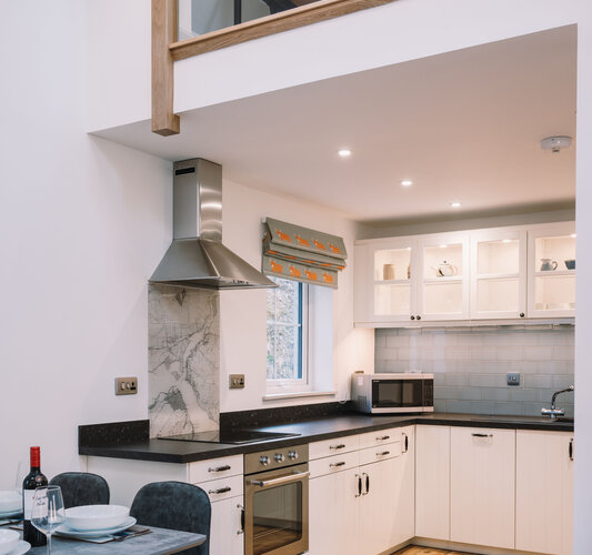 Fully fitted kitchen and dining table with mezzanine gallery above - There's plenty of space for you in the kitchen. It's fully equipped for creating gourmet meals or just snacks.  Dining table next to the kitchen.  And you can see the mezzanine gallery above.