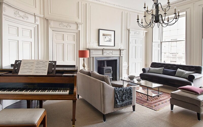 Lounge Area in a Self-Catered Apartment - Stylish lounge area featuring comfortable sofas and a piano, to unwind after a long day in the city of Edinburgh