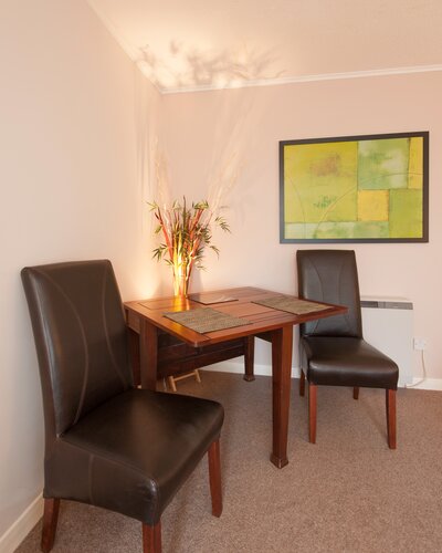 Living Room - Wooden dining table and leather chairs in Edinburgh holiday rental.