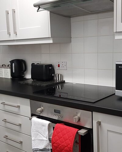 The Dorset Place Residence - White, modern kitchen featuring appliances in Edinburgh self-catering apartment.