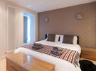 York Place Residence-17 - Double bedroom with decorative feature wall and wooden drawers